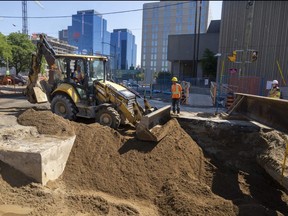 Bruno Urbano of J-AAR Excavation pushes sand into a large hole at the intersection of Ridout Street and Queens Avenue in London. Construction continues to snarl many core routes in the city. Photograph taken on Tuesday, July 19, 2022. 
Mike Hensen/The London Free Press