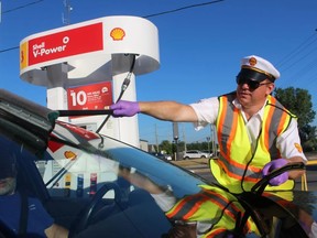Mike Parkhouse, with Shell Canada, cleans the windshield for one of the drivers who took advantage of the company's offer of free gas on Thursday July 21, 2022 at the Don Holden's Shell station in Sarnia. PHOTO BY PAUL MORDEN /The Sarnia Observer