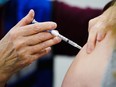 A health worker administers a dose of a COVID-19 vaccine during a vaccination clinic.