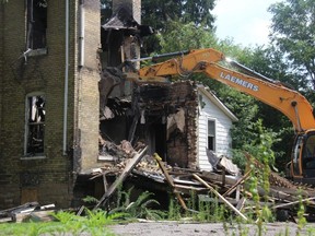 An excavator tears down the walls of the former Walnut Manor in St. Thomas after a fire ripped through the vacant property on Wednesday, Aug. 3, 2022. (JONATHAN JUHA/The London Free Press)