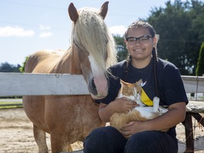 Sixteen-year-old Zhawanoogbiik Riley, with her horse Noodin and her cat Gru, runs a pet food bank in Muncey, Ont. Photo shot on Thursday August 11, 2022. Derek Ruttan/The London Free Press