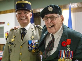 George Beardshaw gives a wink after receiving the National Order of the Legion of Honour medal (beside his poppy) from France's deputy defence attache Colonel Roger Vandomme in London on Sunday Aug. 28, 2022. The military veteran landed on Juno Beach on D-Day and helped liberate France from Nazi Germany. He was also celebrating his upcoming 99th birthday. (Derek Ruttan/The London Free Press)