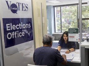 Rejose Mathew, who is running for London District Catholic school board trustee, formally files the paperwork to enter the race with the help of Eman Chamber at the city hall clerk's office in London. Photograph taken on Friday August 19, 2022. Mike Hensen/The London Free Press