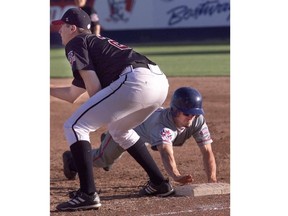 Luke Baker of the London Monarchs dives back to first base to beat the tag from Calgary Outlaws first baseman Trystan Wall during Canadian Baseball League action at Burns Stadium in Calgary on Saturday June 29, 2003. (Ted Jacob/Calgary Herald)