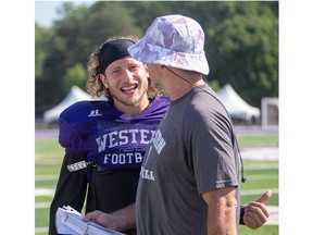 Daniel Valente speaks with defensive co-ordinator Paul Gleason during Western Mustangs football practice at TD Stadium in London on Wednesday. Valente has returned to the university ranks after a stint with the CFL's Ottawa RedBlacks. (Derek Ruttan/The London Free Press)