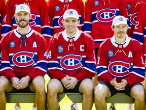 New Montreal Canadiens captain Nick Suzuki is flanked by assistant captains Joel Edmondson, left, and Brendan Gallagher while sitting for a team photo at their annual golf tournament in Laval, north of Montreal, on Monday September 12, 2022. (John Mahoney/Postmedia)