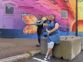 Goderich town square businesspeople Clare Day, left, Nikki Berry, and Jenny Iles show off concrete barriers that could be used to close downtown streets if a possible unsanctioned car rally takes place in the Huron County town this weekend. (Jonathan Juha/The London Free Press)