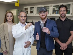 Ethey founder and chief executive Nick Spina, second from right, holds a plastic water bottle that can be broken into mononmers (held by Fanshawe College researcher Istok Nahtigal) that can be used in other products. Ethey and the college teamed up to develop the process.  Flanking the two are Samantha Sowerby and Kyle Standaert of Ethey. Photo shot in London on Tuesday Sept. 20, 2022. Derek Ruttan/The London Free Press