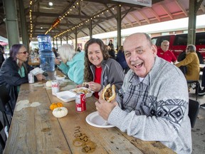 Mark Schleihauf and daughter Richelle Hogarth pause for a bite at the annual harvest lunch hosted by United Way Elgin Middlesex on Thursday, Sept. 22, 2022. The agency launched its fall fundraising campaign at the Horton Farmers' Market in St. Thomas. (Derek Ruttan/The London Free Press)