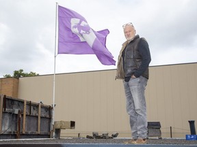 John Scott-Pearse flies a large Western Mustangs flag from the roof of The Belfort where an event is being held on Saturday. (Derek Ruttan / The London Free Press)