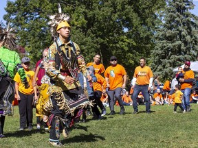 Fifteen-year-old Roger Antone leads a group of people in a Delaware stick dance during National Truth and Reconciliation Day celebrations at the Green in Wortley Village in London on Friday Sept. 30, 2022. (Derek Ruttan/The London Free Press)