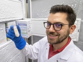 John Chmiel, a microbiology and immunology doctoral student at Western University, holds up a sample of fecal matter kept frozen at -80 C at St. Joseph's hospital in London, on Wednesday, Sept. 14, 2022. St. Joseph’s Health Care is needing  healthy adults willing to donate fecal matter for the beneficial gut microbes harvested to treat stubborn, potentially fatal bowel infection. (Mike Hensen/The London Free Press)