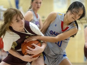 Banting's Aila Salkic and Oakridge's Kim Liu end up with a jump ball after Liu was unable to wrestle the ball away in a Thames Valley senior girls game on Tuesday, Sept. 28, 2022, at Oakridge secondary school. Banting won 43-27. (Mike Hensen/The London Free Press)