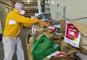 Peter Burns, un volontario presso la London Food Bank, scarica sacchi di generi alimentari da un furgone presso il banco alimentare di Londra, in Ontario, giovedì 2 settembre. 29, 2022. (Mike Hensen/The London Free Press)