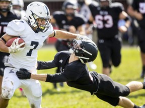 CCH running back Brennan Keba stiff arms STA's Justin Landers in a London District Catholic senior boys game on Thursday, Sept. 29, 2022, at CCH. STA won the season opener for both teams 20-14. (Mike Hensen/The London Free Press)