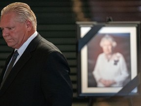 Premier Doug Ford stands in front of a photo of Queen Elizabeth II at Queen's Park in Toronto, Friday, Sept. 9, 2022.&ampnbsp;Ontario's lieutenant governor and premier will proclaim the accession of King Charles III today.&ampnbsp;THE CANADIAN PRESS/Alex Lupul