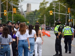 Partygoers walked along Richmond Street, near Broughdale Avenue, on Saturday, September 24, 2022, after emergency crews closed the northbound and southbound lanes for several hours due to Homecoming festivities. (Calvi Leon/The London Free Press)