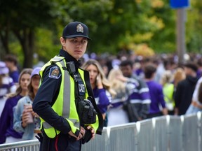 A London police officer keeps a watchful eye over party-goers during Western Univesity Homecoming celebrations on Broughdale Avenue near campus on Sept. 24, 2022. (Calvi Leon/The London Free Press)