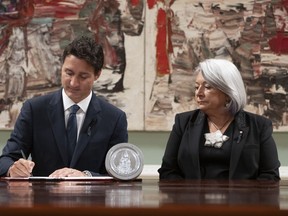 Governor General Mary Simon looks on as Prime Minister Justin Trudeau signs documents during an accession ceremony at Rideau Hall, in Ottawa, Saturday, Sept. 10, 2022.