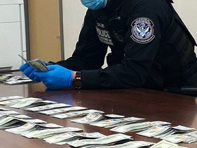 Cash seized at the Blue Water Bridge in Port Huron, Michigan is counted in this photo provided by U.S. Customs and Border Protection.
