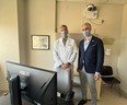Neurologist Jorge Burneo, the chair of neurology in LHSC’s epilepsy program, left, and David Steven, chair of clinical neurological sciences, show off new equipment in an outpatient room at University Hospital on Monday, Oct. 24, 2022. The high-quality camera mounted on the wall syncs with electroencephalogram (EEG) data gathered from sensors on a patient's scalp to give doctors a clearer picture of how a seizure looks in a patient's brain and their physical symptoms. (Jennifer Bieman/The London Free Press)
