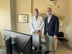 Neurologist Jorge Burneo, the chair of neurology in LHSC’s epilepsy program, left, and David Steven, chair of clinical neurological sciences, show off new equipment in an outpatient room at University Hospital on Monday, Oct. 24, 2022. The high-quality camera mounted on the wall syncs with electroencephalogram (EEG) data gathered from sensors on a patient's scalp to give doctors a clearer picture of how a seizure looks in a patient's brain and their physical symptoms. (Jennifer Bieman/The London Free Press)