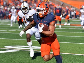 London native Chase Brown (2) scores a touchdown for the Illinois Fighting Illini during the first half against the Minnesota Golden Gophers in NCAA football on Saturday Oct. 15, 2022. (Ron Johnson-USA TODAY Sports)