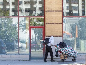A homeless man pushes his belongings along Clarence Street in London on Wednesday, Oct. 5, 2022. (Derek Ruttan/The London Free Press)