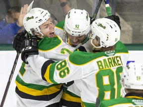 Easton Cowan, left, and Denver Barkey, right, are known as the 'Twins' to their London Knights teammates. They sandwich Jackson Edward with a celebratory hug after Edward scored his first goal in the OHL against the North Bay Battalion at Budweiser Gardens in London on Oct. 28, 2022. (Derek Ruttan/The London Free Press)