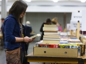 Haley Guscott peruses another book to add to her sizeable collection at the Friends of the London Public Library Library used book sale in the basement of Centennial Hall in 2019. The sale returns Oct. 14-16. (Mike Hensen/The London Free Press)