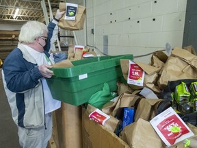 Eric Hobden, a volunteer at the London Food 
Bank, unloads bags of groceries from a van at the food bank Thursday as the fall food drive winds down.  (Mike Hensen/The London Free Press)