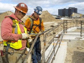 Mike Sousa and Kyle MacDaniel of Nucor Harris Rebar tie in rebar for the walls that will soon go up in the Eve Park residential development west of Sifton's West 5 community in west London. Eve Park, like West 5, is intended to be a net-zero community, meaning it will generate as much electricity as it uses. Photograph taken on Friday, Oct. 7, 2022. (Mike Hensen/The London Free Press)