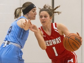 Tess Alcock of Medway brushes past the defence of Gigi Bieman of Lucas in a senior girls basketball game at Lucas on Monday, Oct. 17, 2022. Lucas won 43-39. Mike Hensen/The London Free Press
