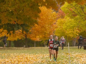 Charlotte Cromack of Mother Teresa leads Medway’s Haley Haskett on the first lap of their five-kilometre junior girls race at the TVRA cross-country championships held Thursday Oct. 20,2022 in Springbank Park. (Mike Hensen/The London Free Press)