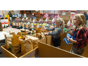 The Barnett sisters, Zoe, 7, and Charlie, 9, volunteer at the London Food Bank on Monday October 10, 2022. Mike Hensen/The London Free Press