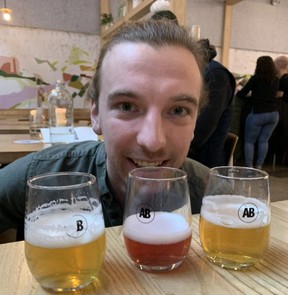 Smiling Alving server Tristan delivers a beer tasters selection, including brews from barrel-aged batches. (Barbara Taylor/The London Free Press)