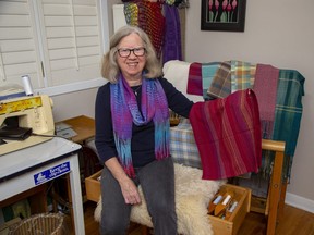 Linda Elkins displays one among many tea towels she wove on loom in her home studio. The towel is among many items for sale at the fibre arts festival at Covent Garden Market Nov. 18-20. (Derek Ruttan/The London Free Press)