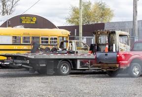 A pair of fire-damaged tow trucks are parked at Low Price Towing on Clarke Road, London, Monday, November 14, 2022. (Derek Rutten/The London Free Press)