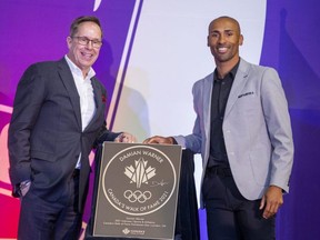 Jeffrey Latimer, chief executive of Canada's Walk of Fame, and reigning Olympic decathlon gold medalist Damian Warner unveil Warner's Canada's Walk of Fame plaque during a ceremony at Western University in London on Monday, Nov. 14, 2022. (Derek Ruttan/The London Free Press)