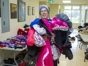 Jeff Holbrough, principal of J.P. Robarts elementary school in London, displays some of the donated children's winter clothing that will be available for parents to choose from when they come for parent-teacher interviews this week. Photograph taken on Tuesday, Nov. 15, 2022. (Derek Ruttan/The London Free Press)