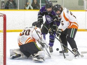 Clarke Road Trojans player Carter Polishuk and Rhick Hales of the West Elgin Wildcats battle for a rebound in front of Trojans goalie Tyler Strain during their varsity high school hockey game at Argyle Arena in London on Monday November 28, 2022. The home team Trojans won the game, 1-0. Derek Ruttan/The London Free Press