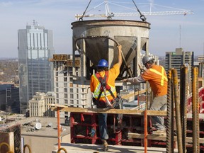 Rob Macgillivray and Dylan Churchill pour the walls of the 23rd floor at 131 King St. in London, Ont.,  on Friday, Nov. 4, 2022. The York Developments tower directly across from the Covent Garden Market will top out at 31 floors, with more than 260 units.  (Mike Hensen/The London Free Press)