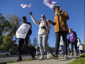 Striking education workers with the Canadian Union of Public Employees (CUPE) walk a picket line on Commissioners Road near Wharncliffe Road in London on Monday, Nov. 7, 2022, the second day their walkout had shuttered most schools here and provincewide. Mike Hensen/The London Free Press