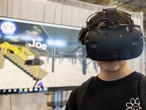 Amelie Robichaud, 14, of Oakville, is shown a virtual reality headset during a skilled trades job fair at the Western Fair Agriplex in London on Wednesday, Nov. 9, 2022. Students from as far as the Niagara school board are attending the two-day job fair. (Mike Hensen/The London Free Press)