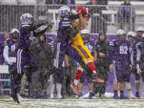 Jackson Findlay of the Western Mustangs times his leap perfectly to break up a pass intended for Richard Burton of the Queen’s Gaels with teammate Richard Aduboffour looking for a possible interception during a snowy Yates Cup at Alumni Stadium in London on Saturday Nov. 12, 2022. Mike Hensen/The London Free Press