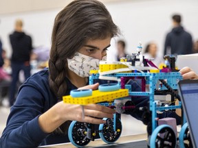 Olivia Flores 14, of St. Mary’s Catholic High School in Woodstock studies the robot her team had made as part of the Oxford Invitational Youth Robotics Challenge in Woodstock on Tuesday November 15, 2022. 14 high schools participated. (Mike Hensen/The London Free Press)