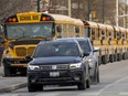 A long line of school buses waits on Dundas Street in front of Catholic Central high school in London on Thursday November 17, 2022. (Mike Hensen/The London Free Press)