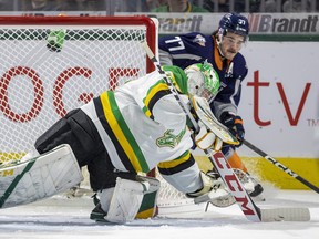 Zacharie Giroux of the Flint Firebirds comes from behind the net to try for a puck as Brett Brochu of the London Knights dives onto it during their OHL game on Friday Nov. 18, 2022 at Budweiser Gardens in London. Mike Hensen/The London Free Press/Postmedia Network