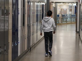 A student walks through the hallway of his school in this Postmedia file photo.