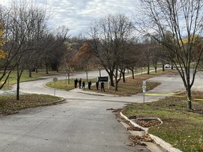 Six London police officers search for evidence at the Grosvenor Street entrance to Gibbons Park on Sunday Nov. 6, 2022. An unidentified male was found unresponsive in the area Sunday morning and later pronounced dead. (Jennifer Bieman/The London Free Press)